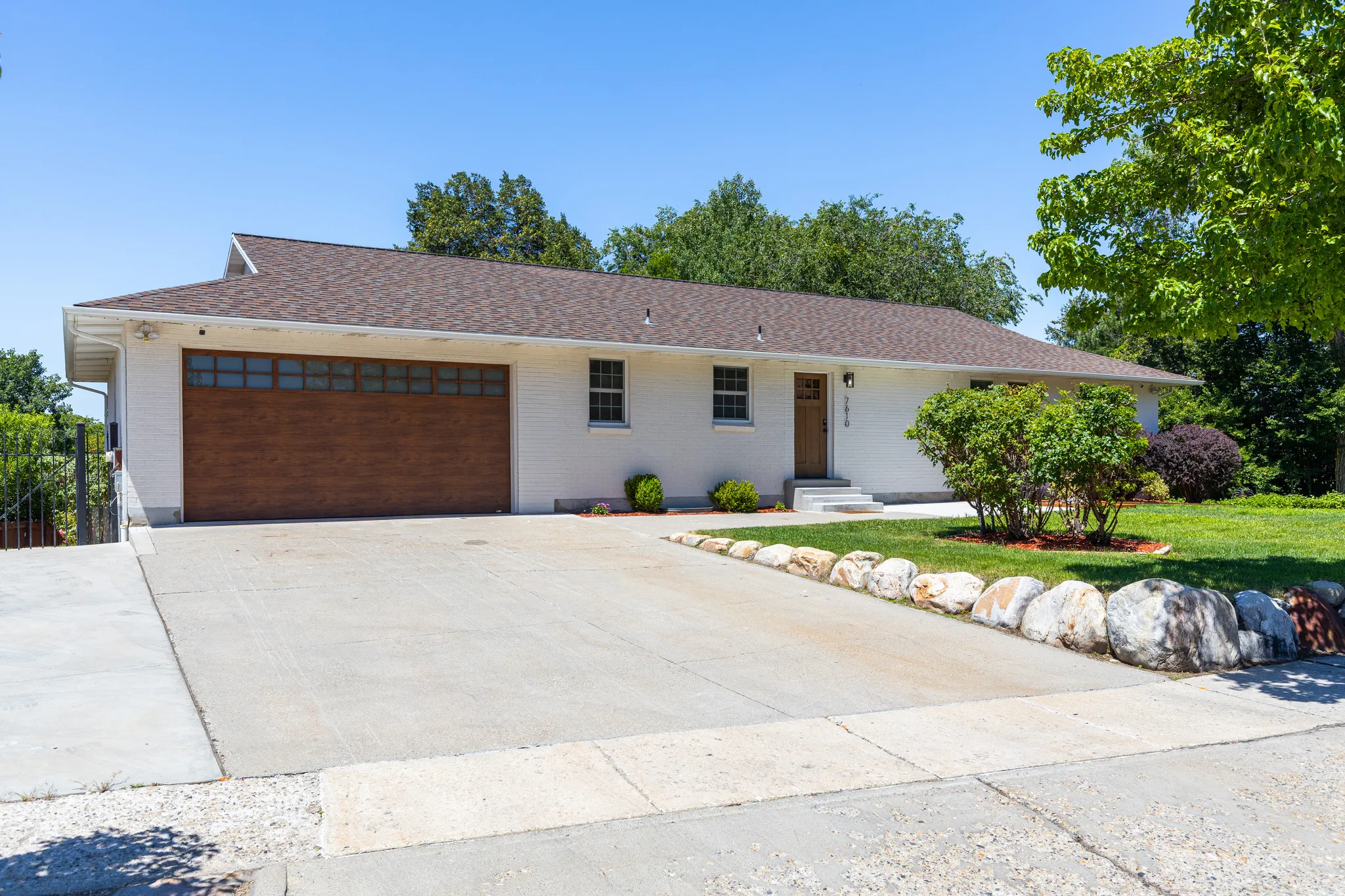 White exterior with a prominent wood-finish garage door