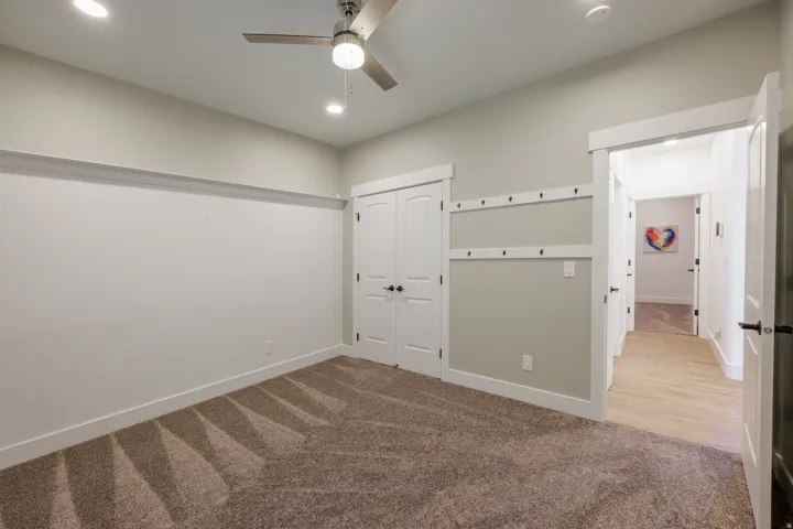 Carpeted room featuring recessed lighting, a modern ceiling fan, and white beadboard wall paneling