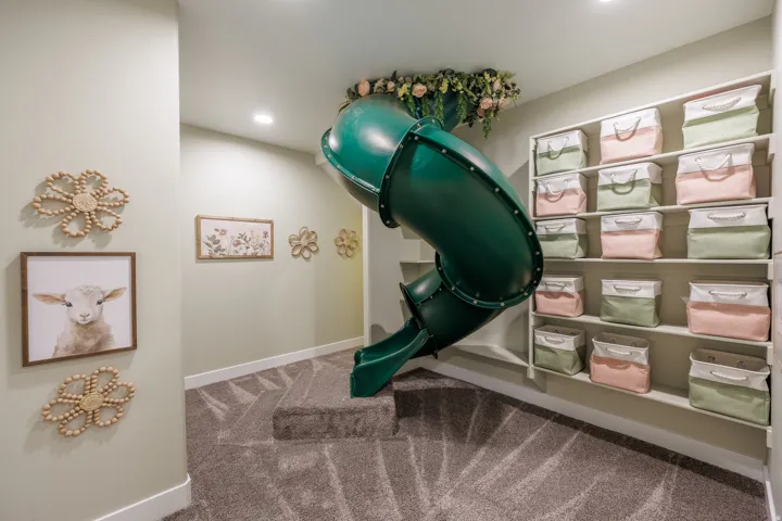 Indoor slide feature with carpeted steps, recessed lighting, and wall-mounted shelving