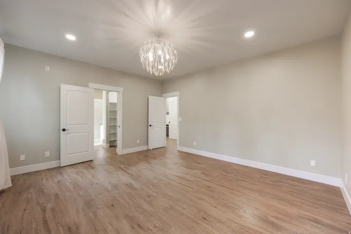 Spacious main bedroom featuring an ensuite, 2 walk-in closets and door to deck with hot tub.