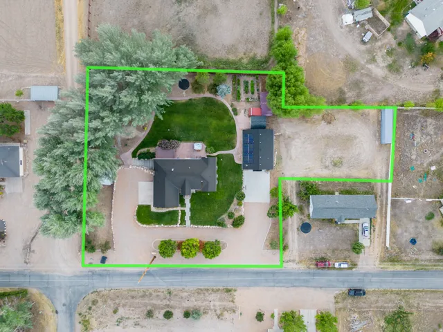 Aerial perspective highlighting a primary residence, a secondary structure, and extensive grounds