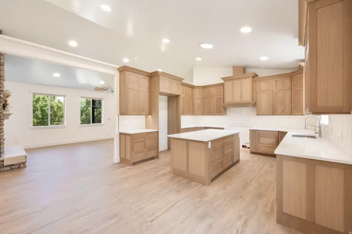 Large open Kitchen featuring light oak wood cabinetry, a large island, and top of the line LVP flooring. A luxury stove and dishwasher will be installed before closing