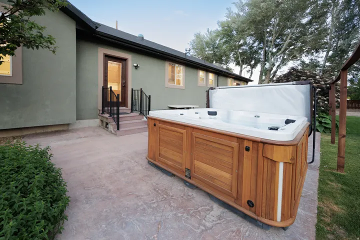Outdoor patio featuring a saltwater spa with wood-finish paneling