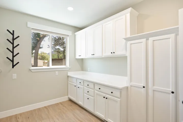Upstairs Laundry with Wood-finish flooring, white cabinetry, a single window, and recessed lighting. Hookup for 2 washers and 2 dryers (gas or electric)