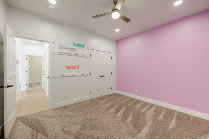 Bedroom featuring plush carpet flooring, a ceiling fan with integrated lighting, recessed ceiling lights, and double panel doors