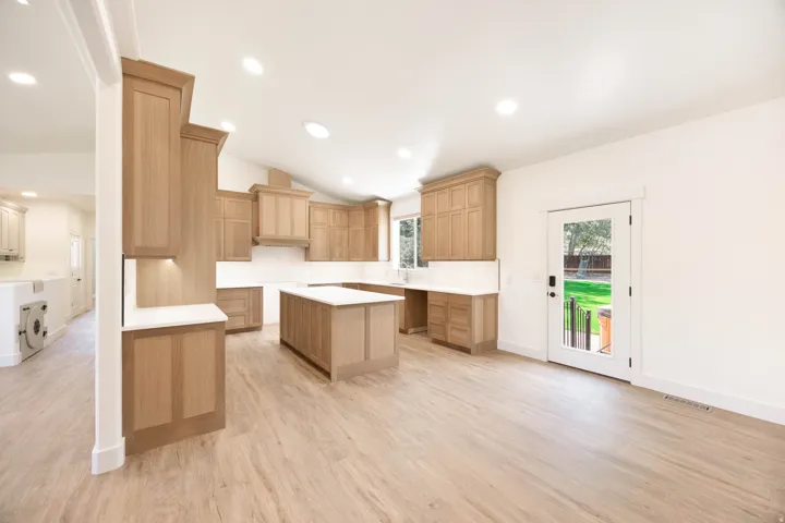 Large open Kitchen featuring light oak wood cabinetry, a large island, and top of the line LVP flooring. A luxury stove and dishwasher will be installed before closing