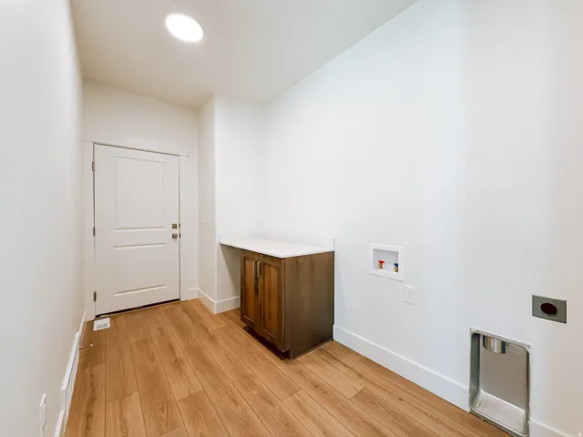 Wood-finish flooring, recessed lighting, built-in cabinetry, and a white countertop