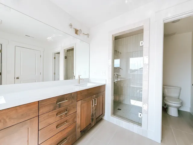 Wide vanity with wood-finish cabinetry, white countertop, and integrated sink