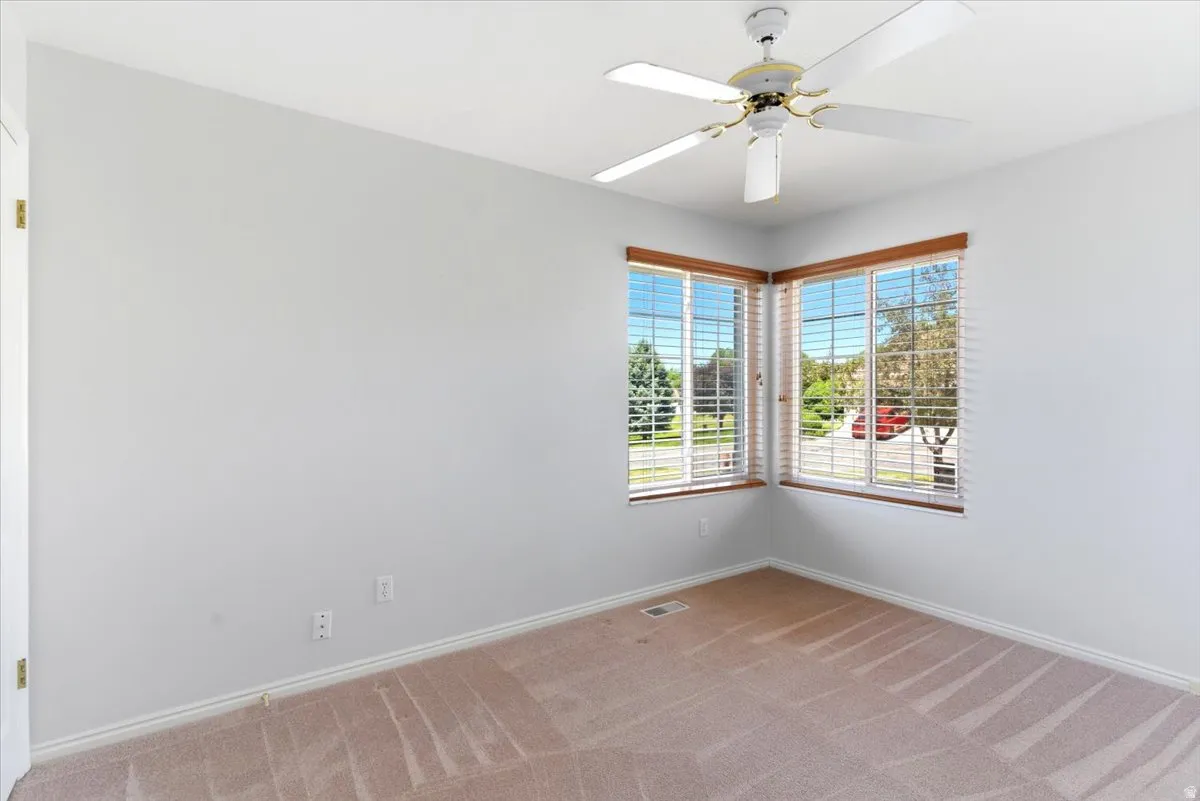 Second Bedroom. Corner window arrangement featuring horizontal blinds and wood-finish trim