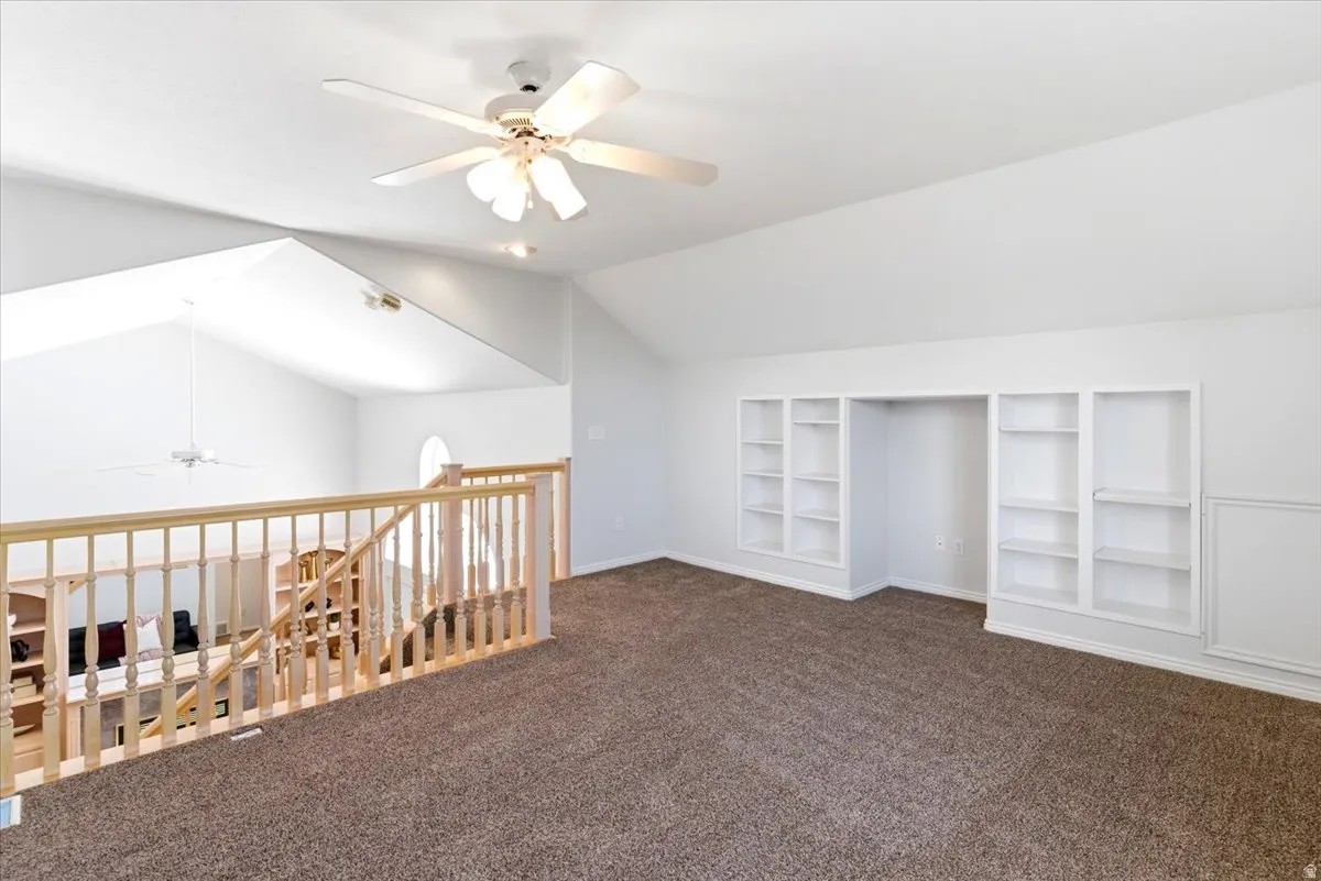 Spacious loft area featuring vaulted ceilings, recessed lighting, ceiling fan, built-in shelving, and light wood railing. Listed as 3rd bedroom.