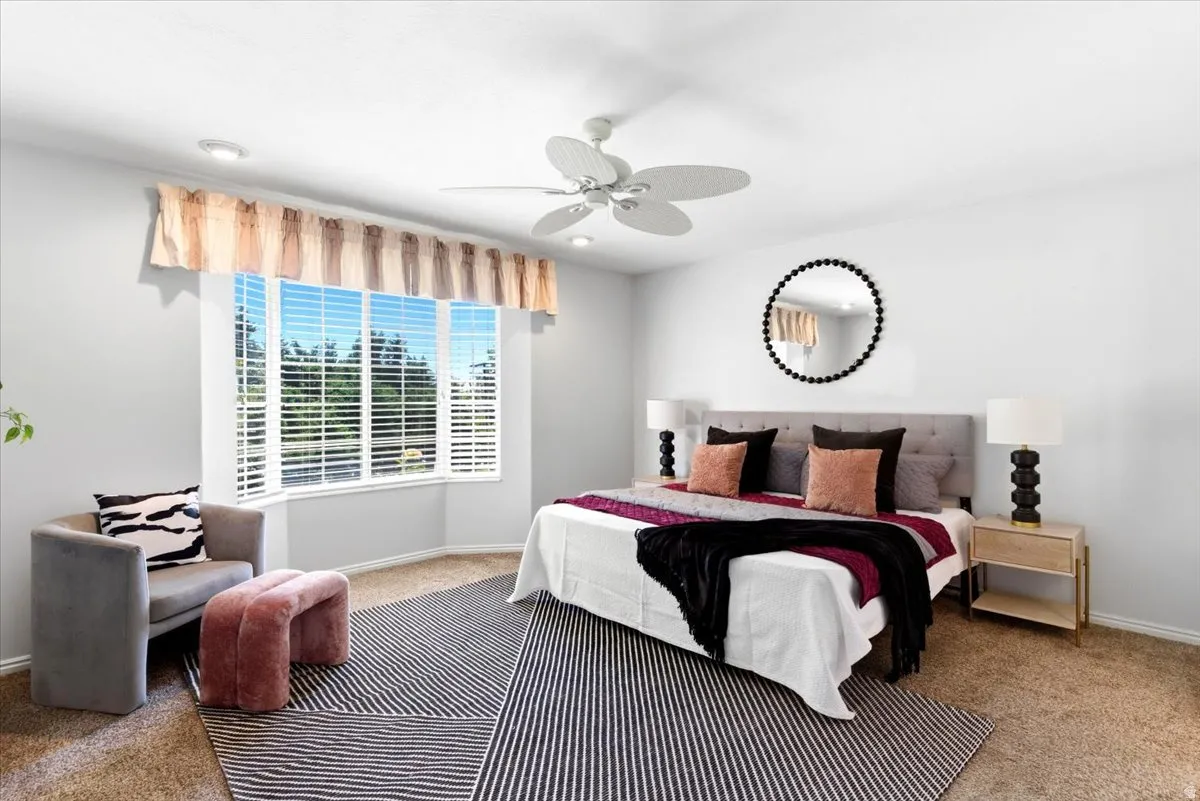 Primary Bedroom with bay window with white blinds, ceiling fan, and recessed lighting