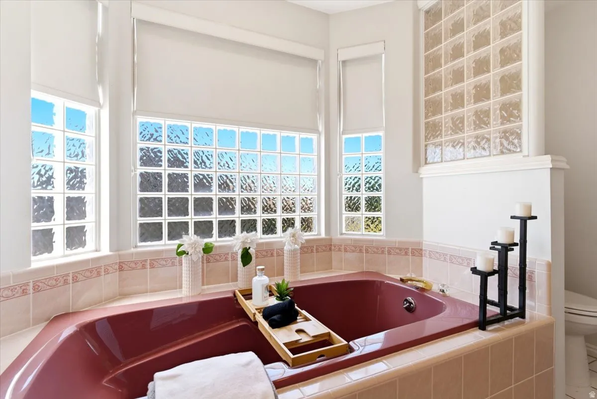Primary bathroom with deep soaking tub, tile surround, featuring patterned accent tile