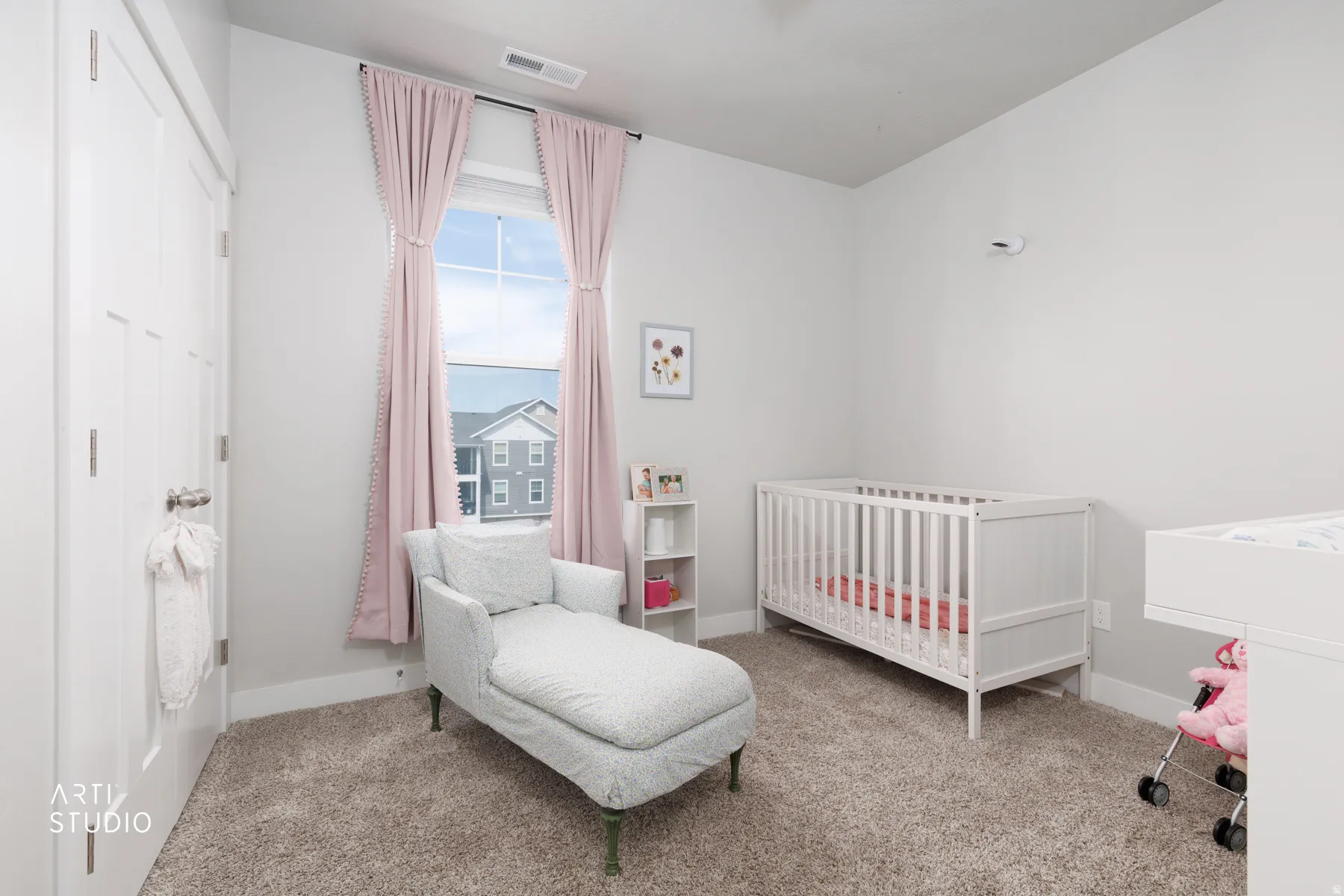 Spacious room featuring neutral wall tones, large window, and plush carpeting