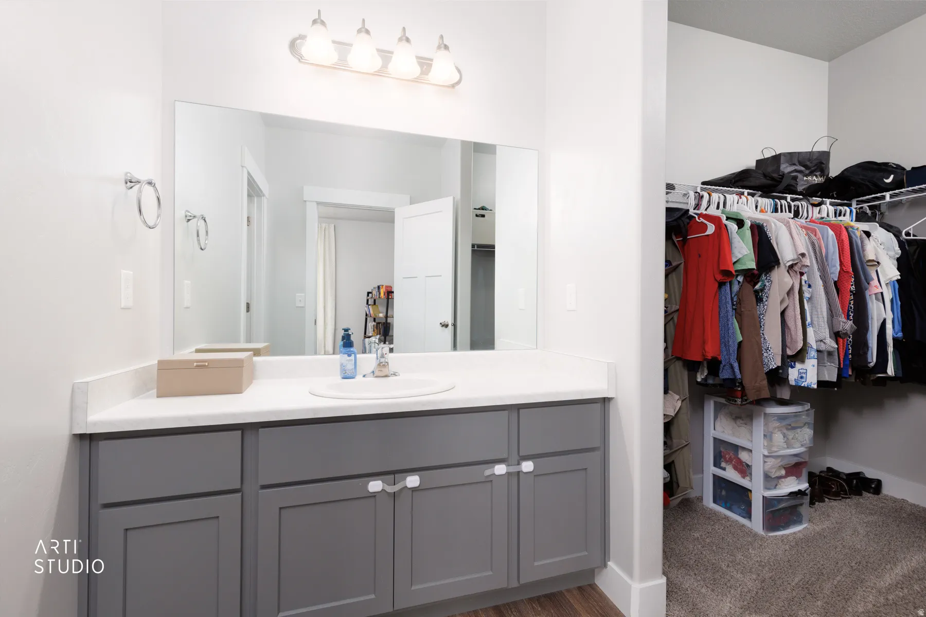 Vanity area featuring a single basin sink, light-toned countertop, and gray shaker-style cabinetry with white hardware