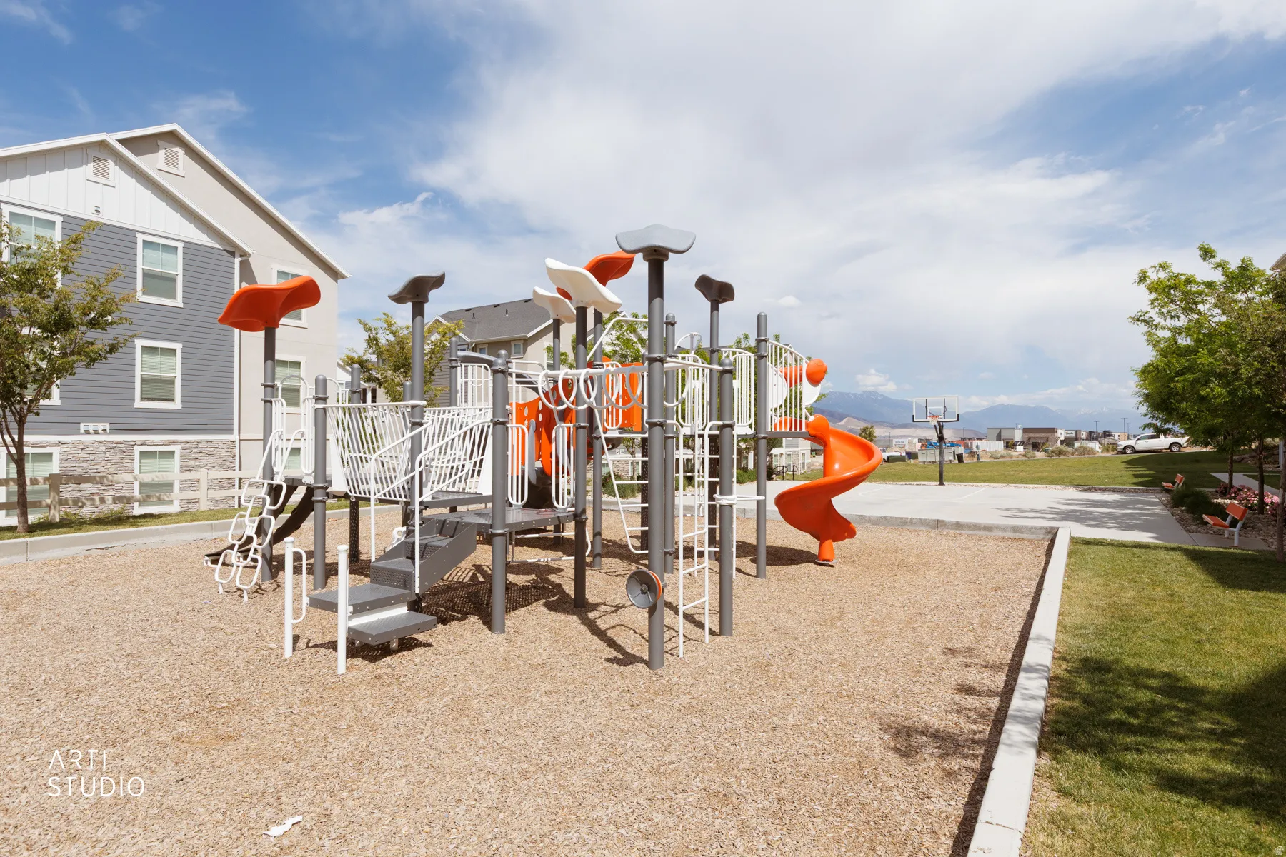 Community playground featuring multiple slides and climbing structures on a wood chip surface