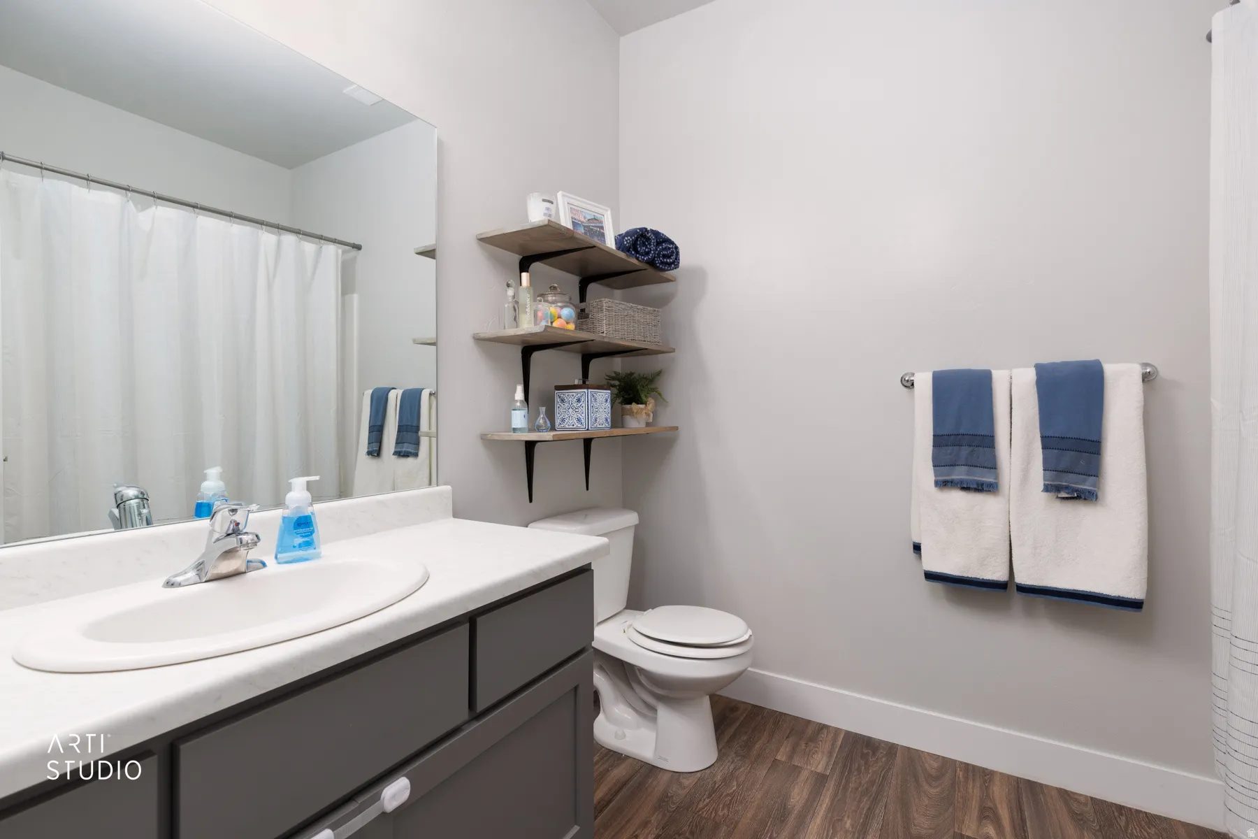 Bathroom with a vanity featuring a white countertop and gray cabinetry