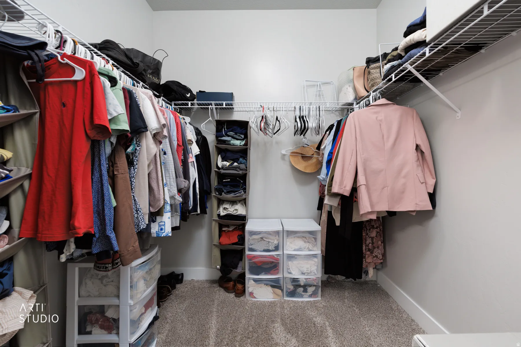 Walk-in closet featuring light gray walls, plush carpeting, and extensive wire shelving for organization