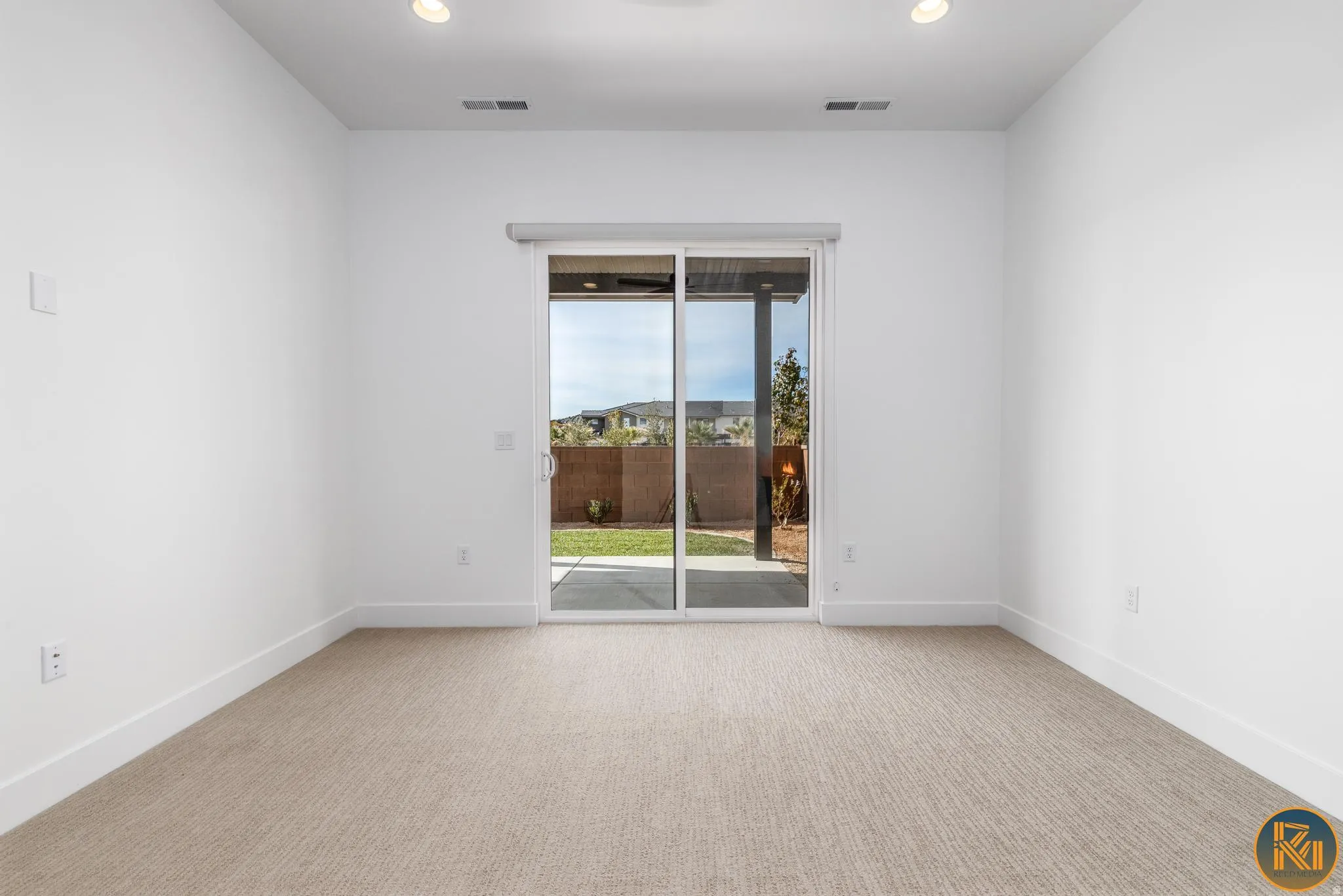 Room featuring a sliding glass door leading to a patio and a landscaped yard