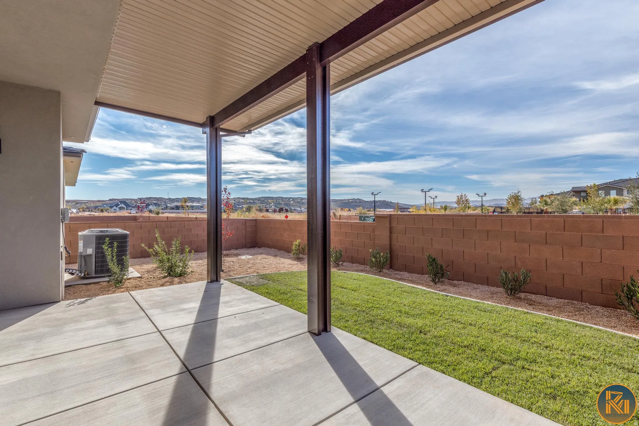 Covered concrete patio with a structured metal overhang