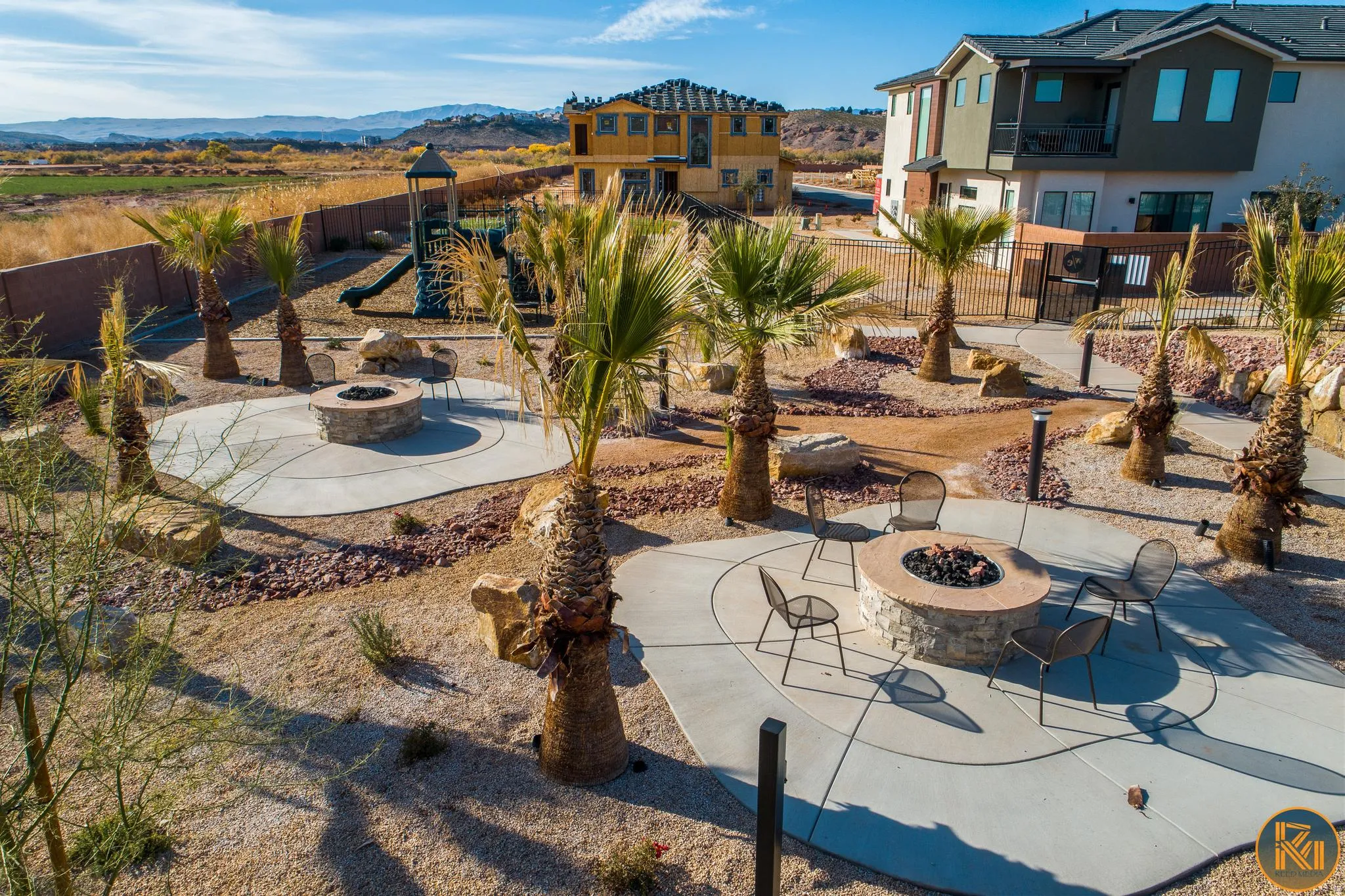 Landscaped outdoor area featuring multiple circular concrete patios, each with a stone-clad fire pit