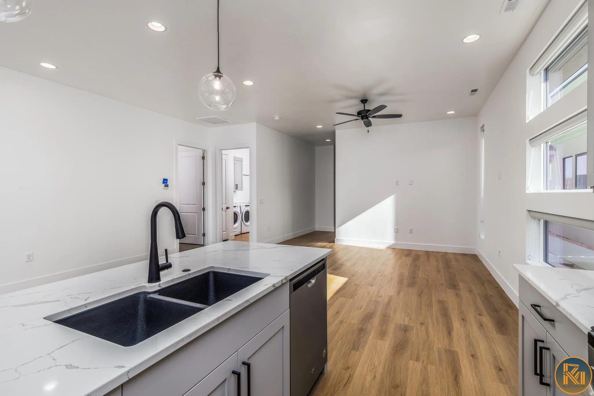 Kitchen island with a double basin sink, matte black faucet, and white countertop