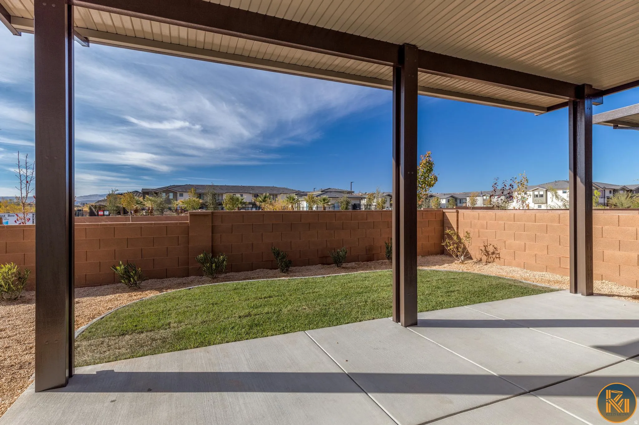 Covered patio featuring a concrete slab, metal support columns, and an insulated ceiling