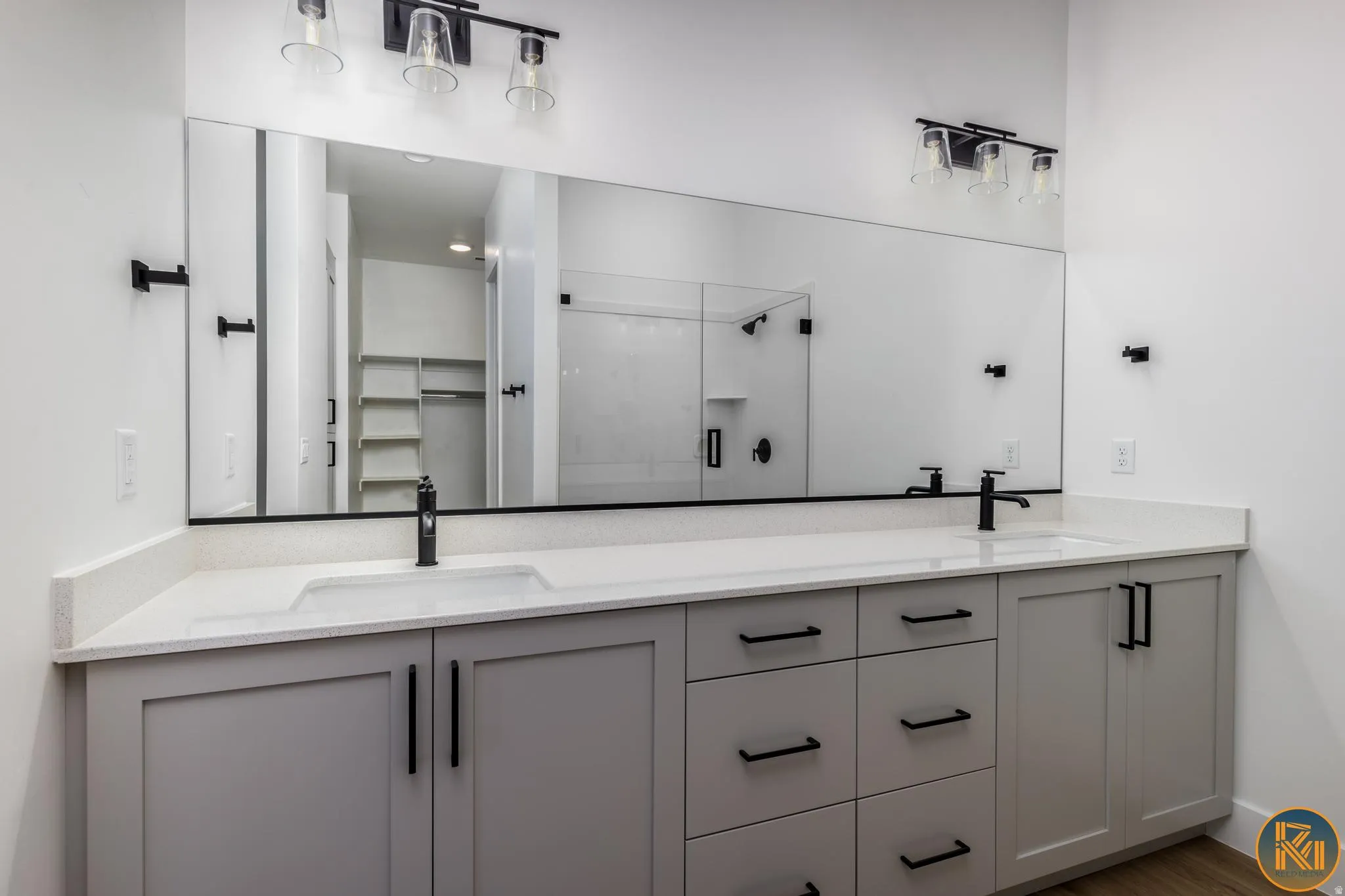 Dual vanity with light-toned cabinetry, white countertops, and matte black fixtures