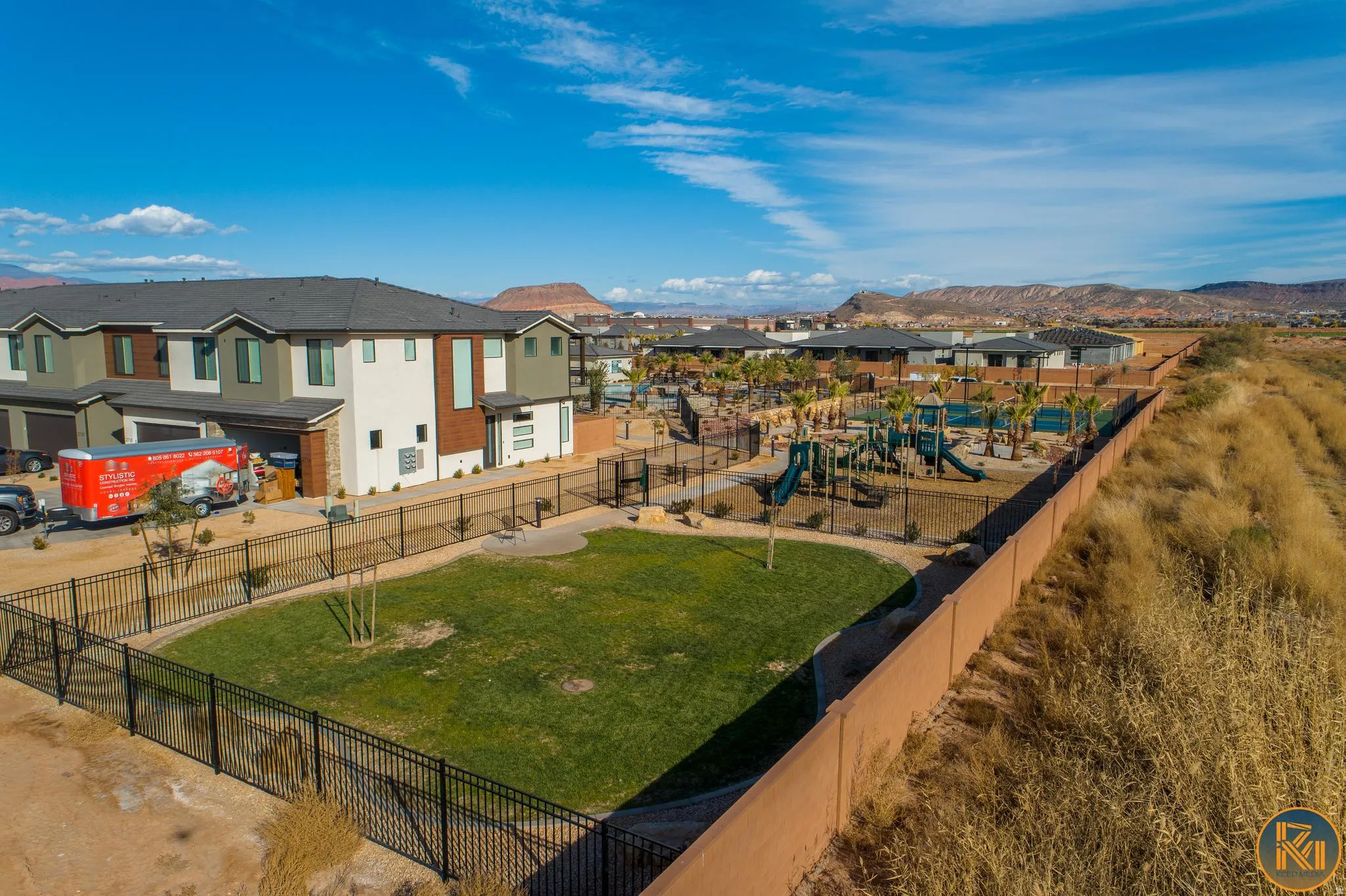 Community green space featuring a manicured lawn and black metal fencing