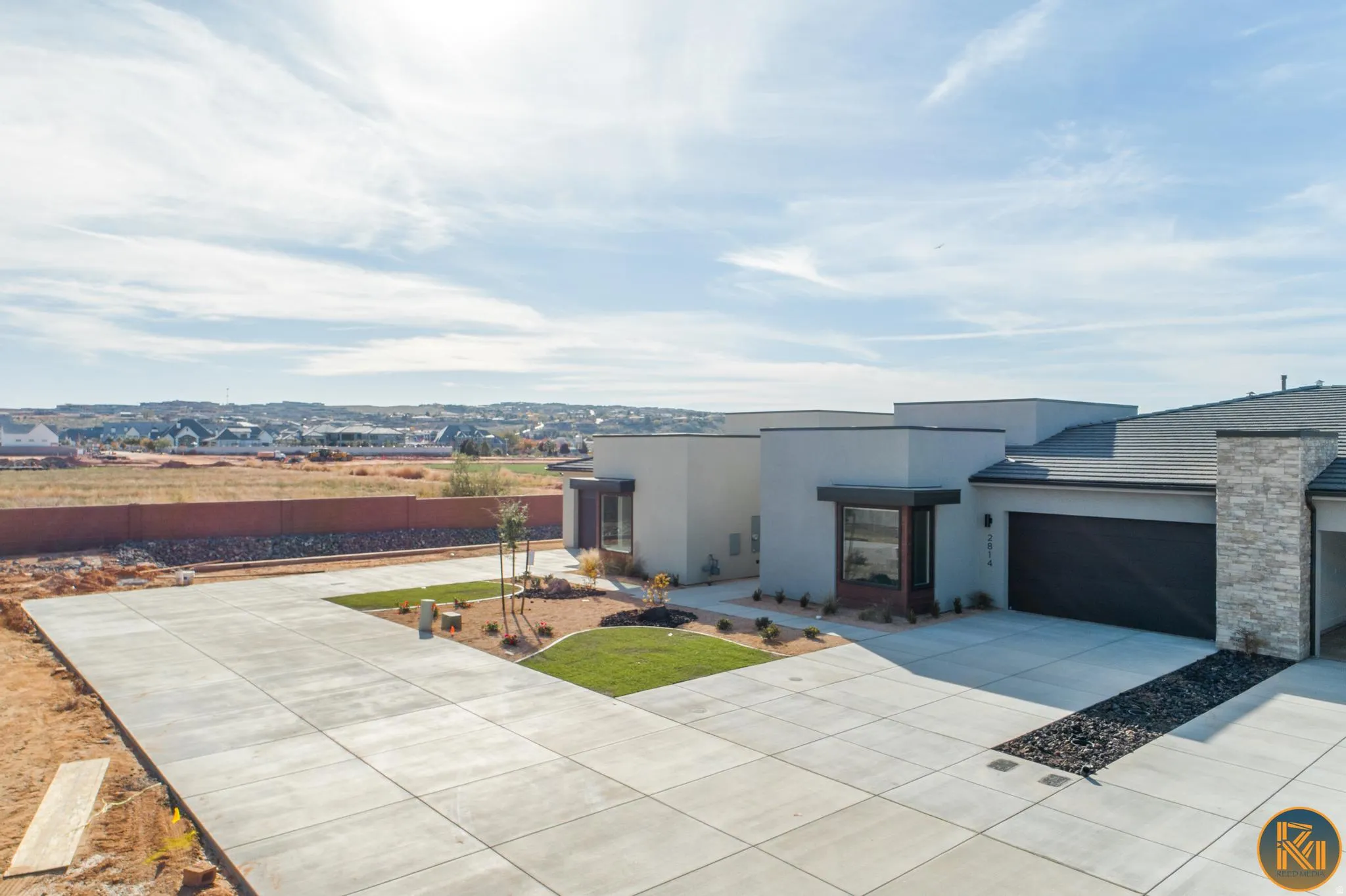Contemporary exterior architecture with a flat roofline, stucco finish, and stone accent column