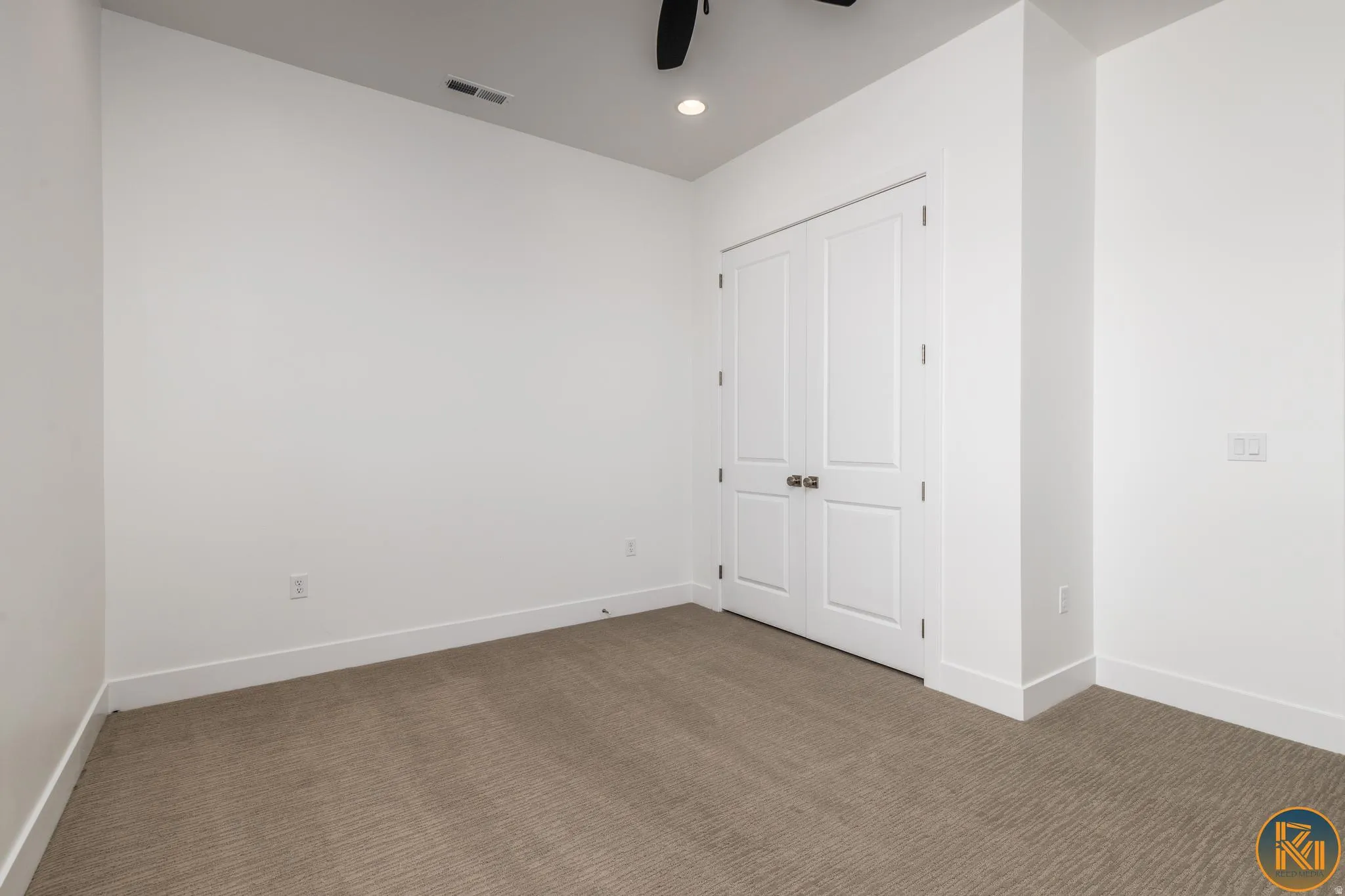 Spacious room featuring neutral carpet flooring and white walls