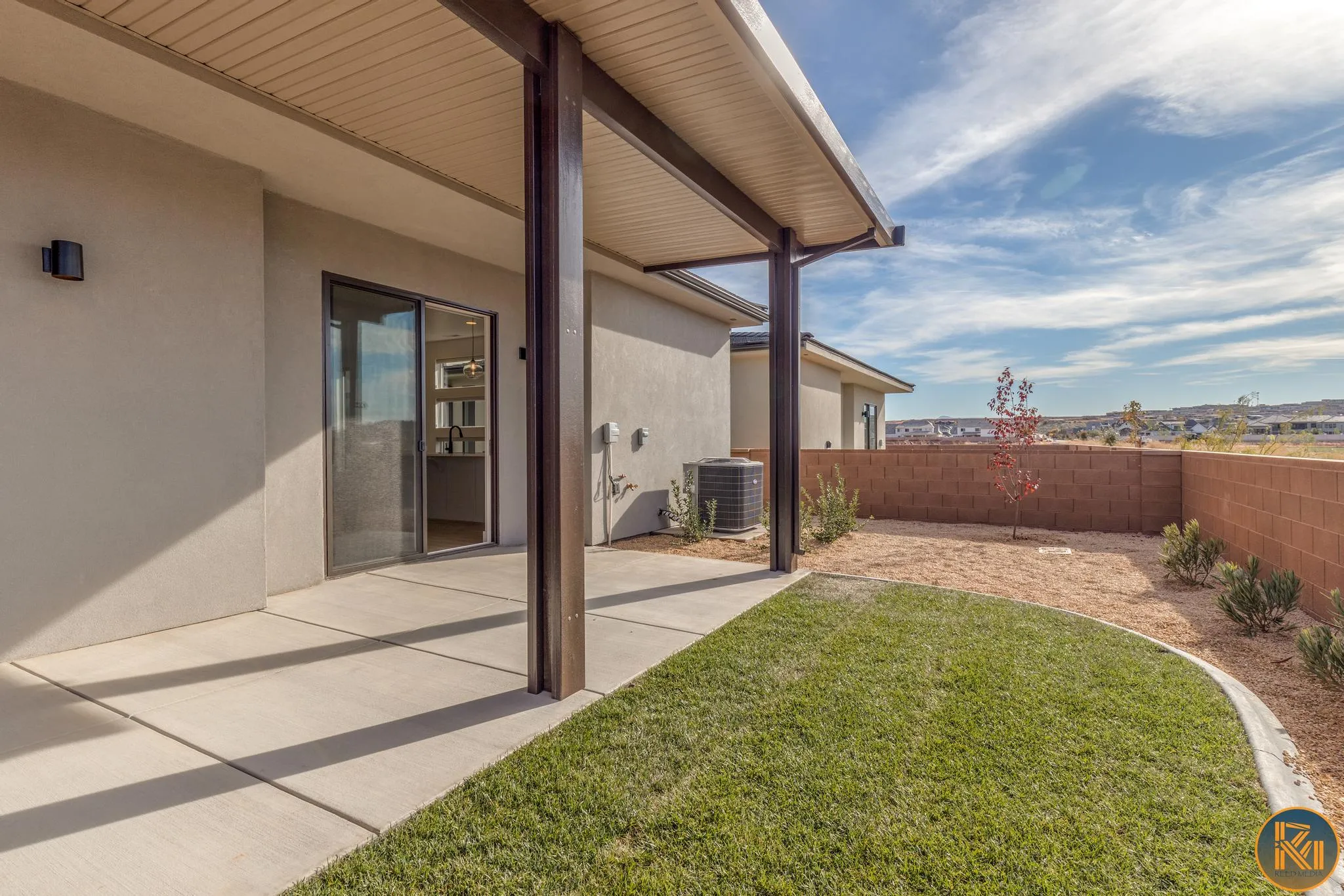Expansive concrete patio with a covered outdoor area, providing shade and outdoor living space