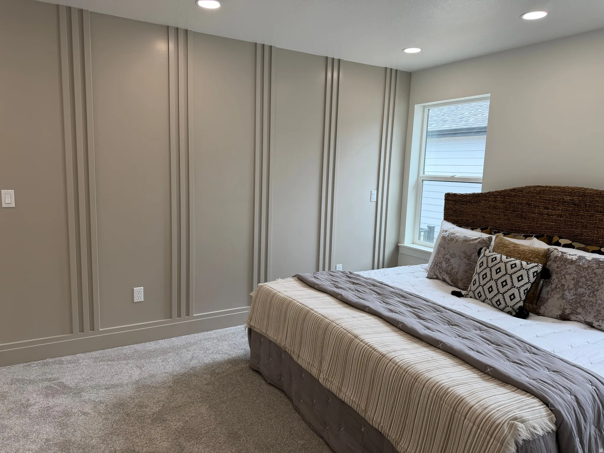 Recessed lighting illuminates a feature wall with vertical trim detailing