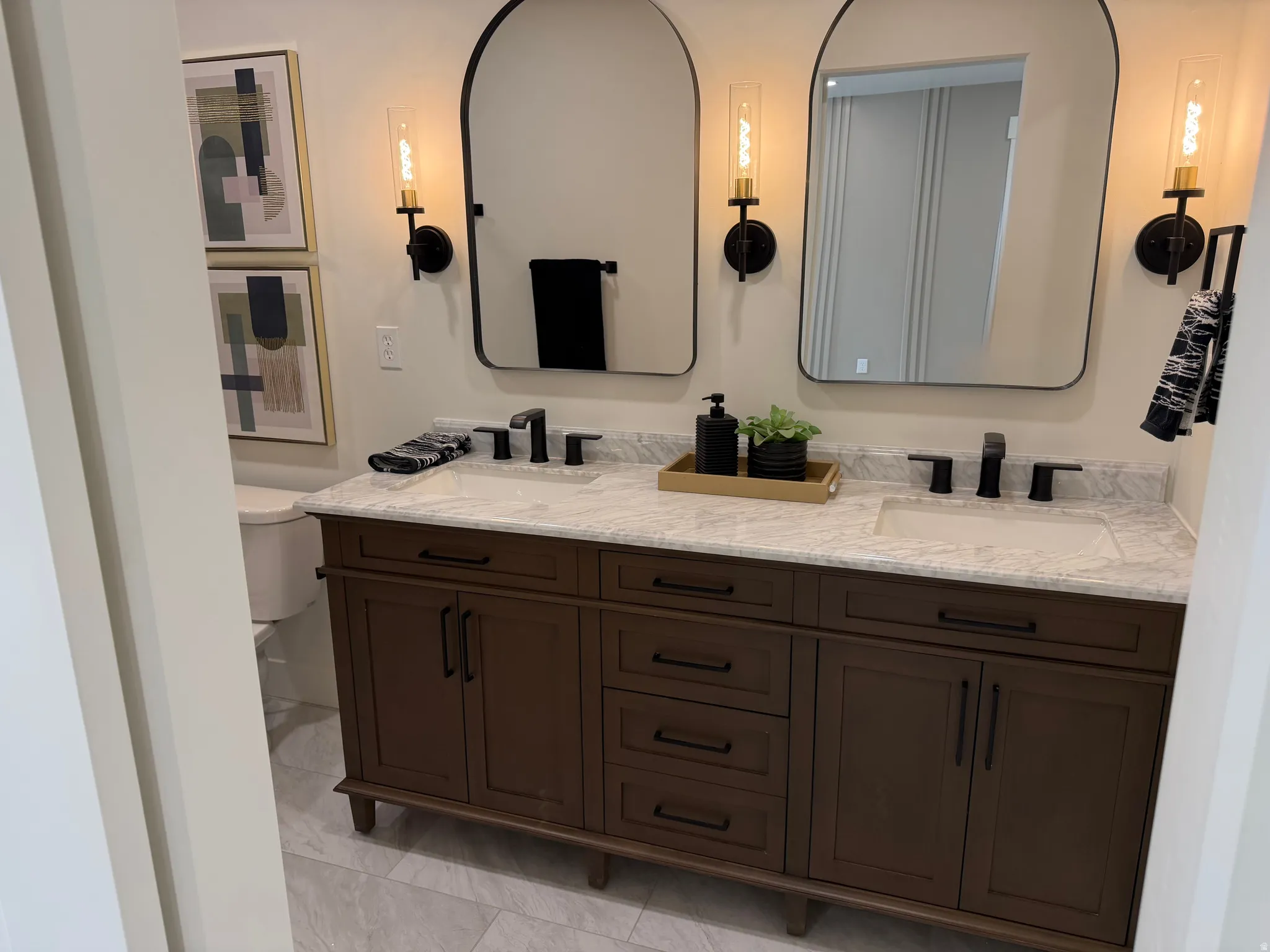 Double vanity with wood-finish cabinetry, white countertop, and integrated sinks
