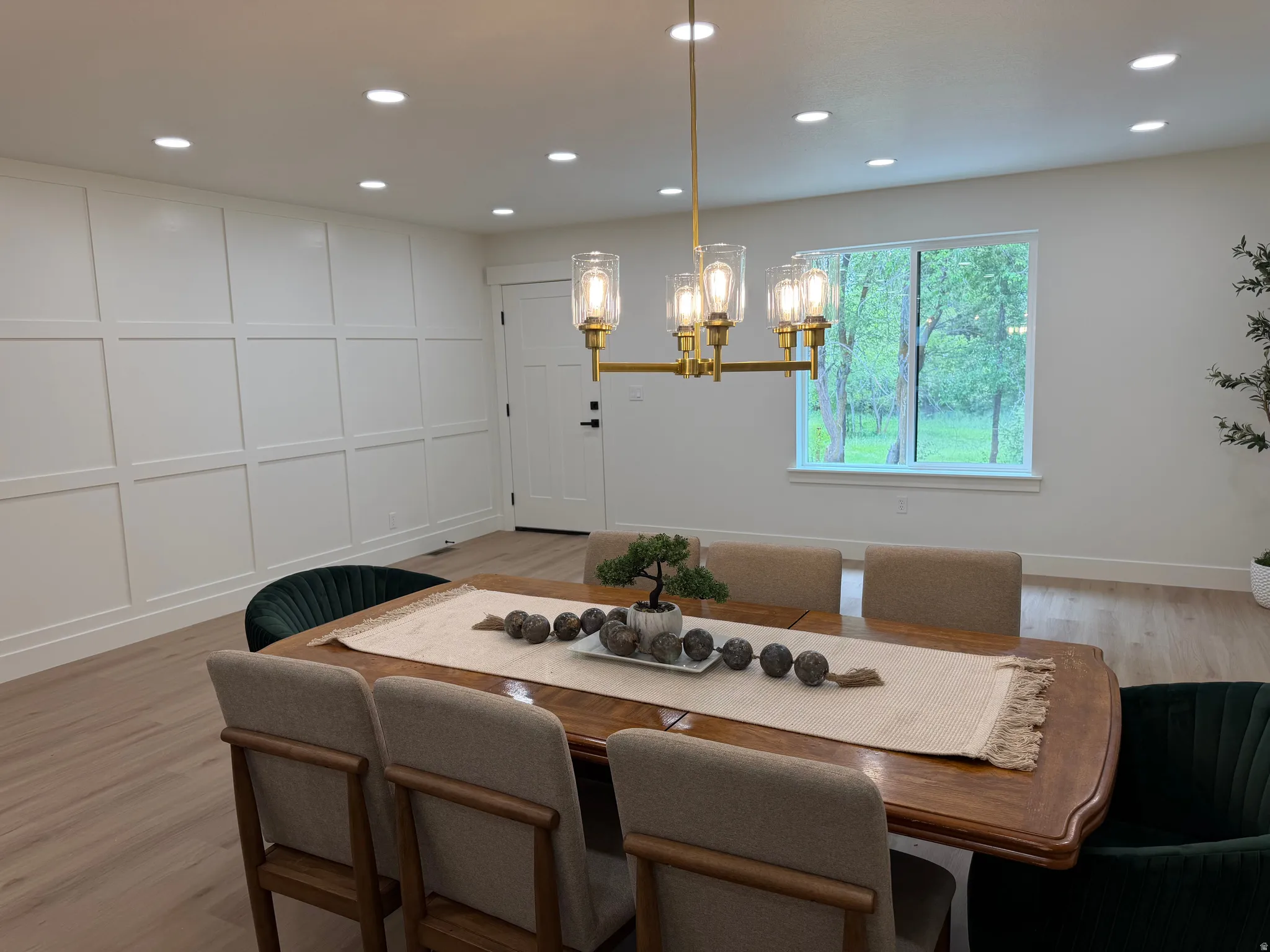 Dining space featuring a gold-finish linear chandelier, recessed lighting, and light wood-finish flooring