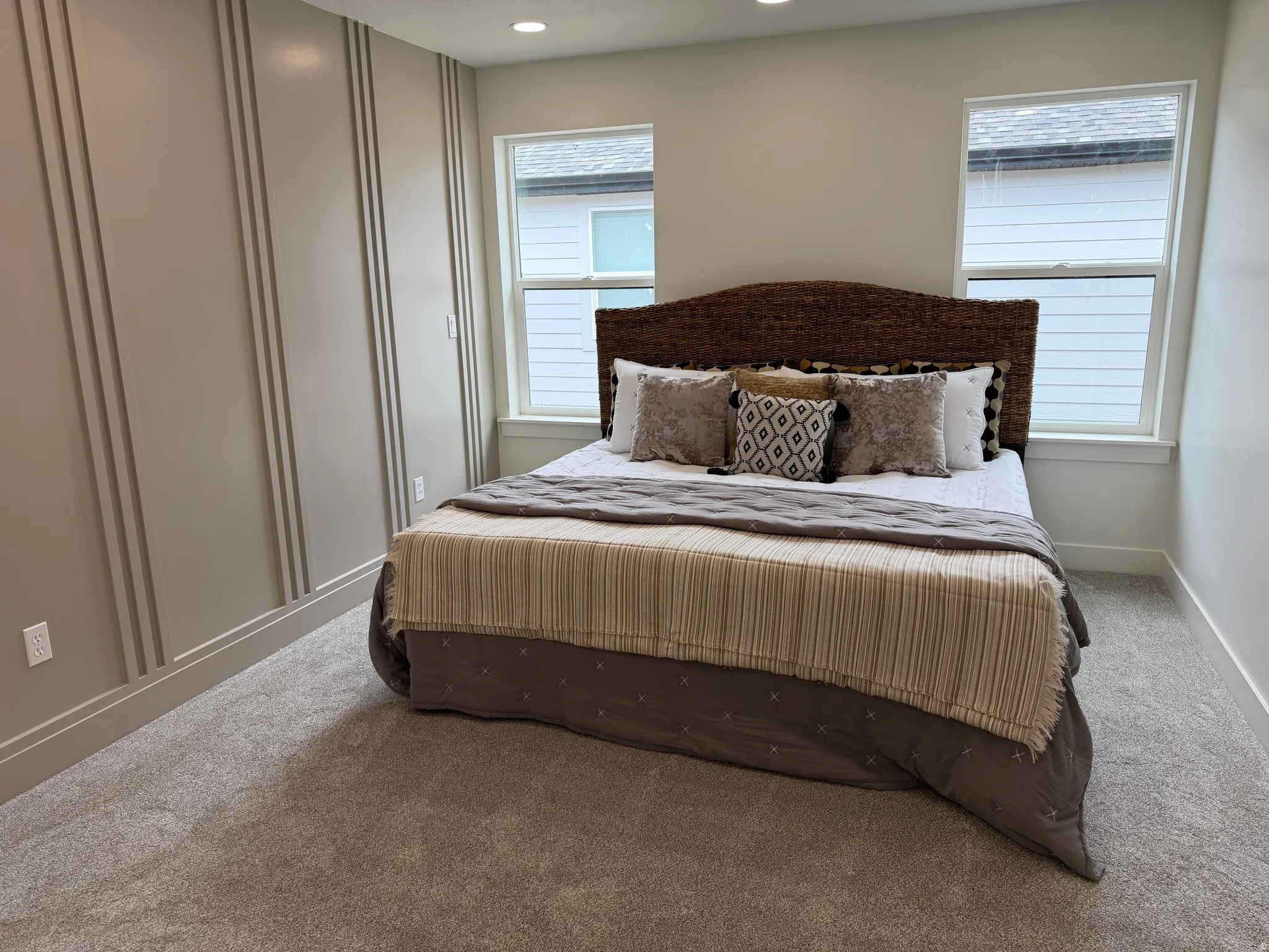 Bedroom featuring decorative wall molding, recessed lighting, two windows, baseboard trim, and light-colored carpeting