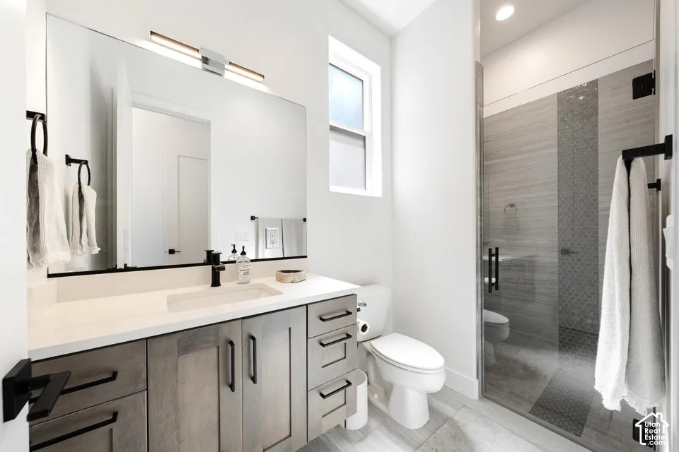 Modern bathroom featuring a single vanity with a light wood-finish cabinet, white countertop, and integrated rectangular sink