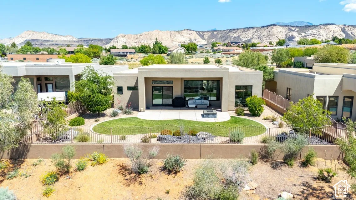Modern flat-roof architecture featuring a private patio, landscaped lawn, and low-maintenance desert plantings