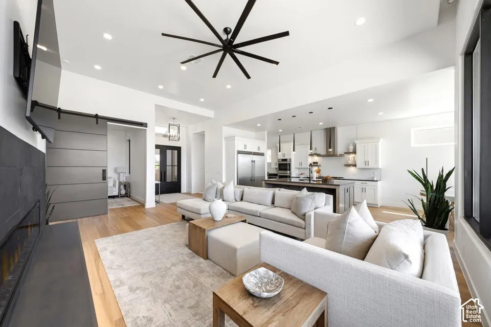 Bright living space featuring wood-finish flooring, recessed lighting, and a contemporary ceiling fan