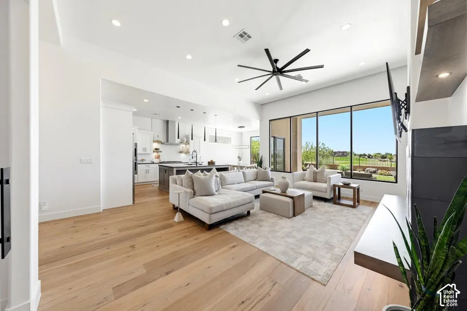 Open-concept living space featuring wood-finish flooring, recessed lighting, and a contemporary ceiling fan