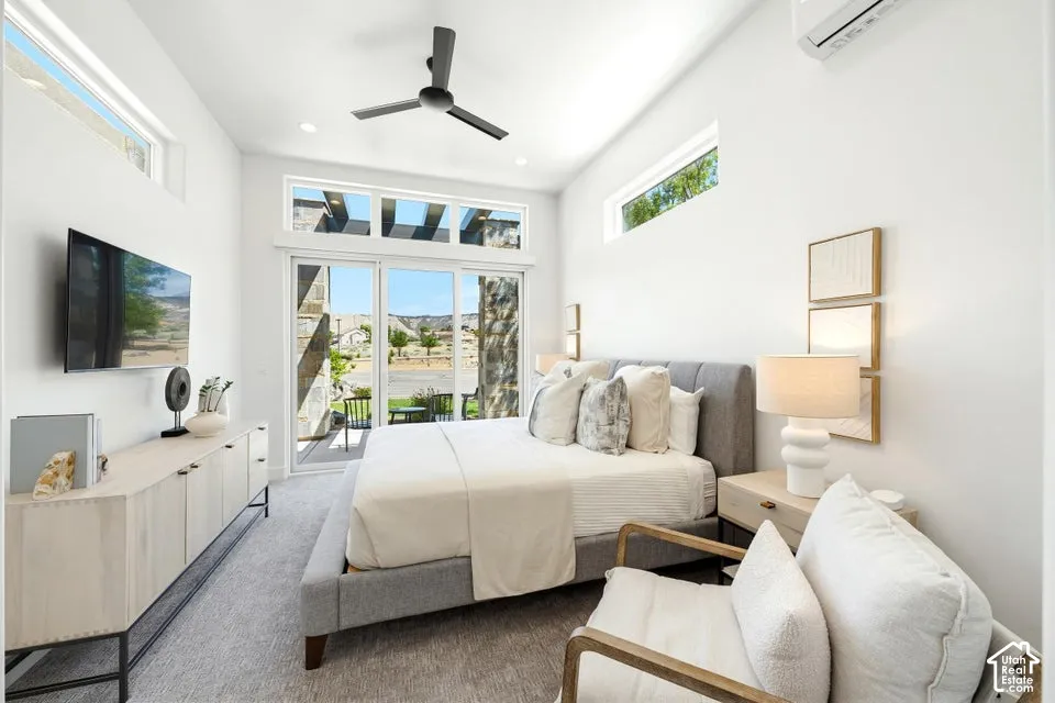 Light-filled bedroom featuring a vaulted ceiling with a modern ceiling fan, clerestory windows, and sliding glass doors opening to an outdoor patio