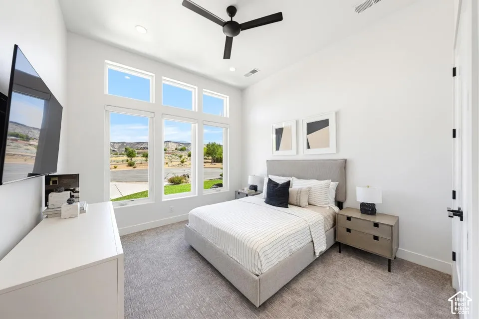 Vaulted ceiling bedroom with a prominent window wall, featuring six individual panes overlooking the exterior surroundings