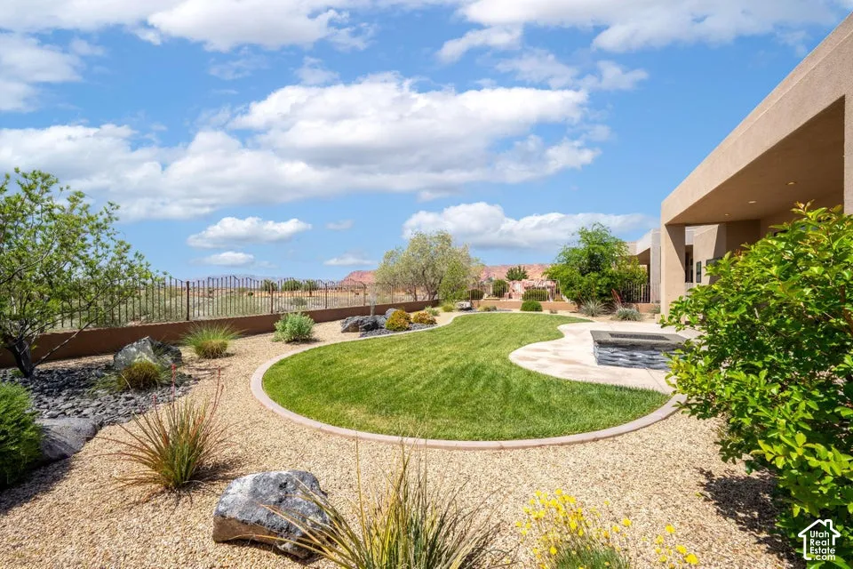 Expansive backyard featuring a curvilinear lawn, gravel ground cover, and mature desert landscaping