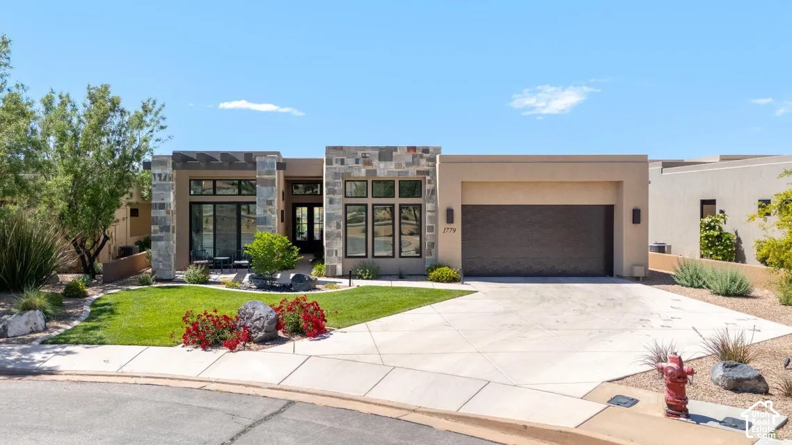 Contemporary stucco exterior with stone accents and a flat roofline