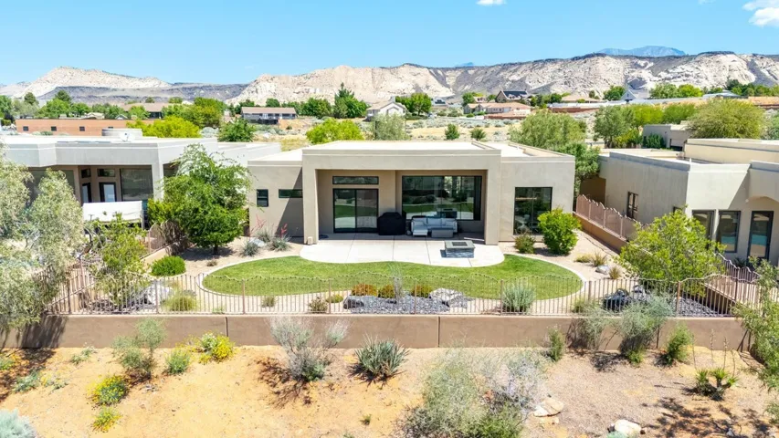 Modern flat-roof architecture featuring a private patio, landscaped lawn, and low-maintenance desert plantings