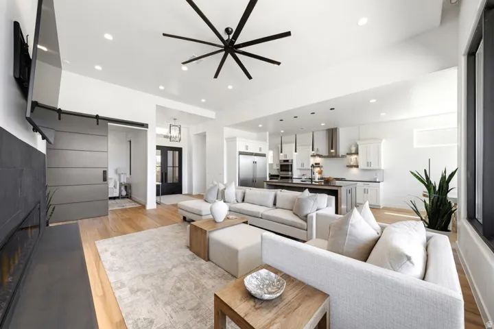 Bright living space featuring wood-finish flooring, recessed lighting, and a contemporary ceiling fan