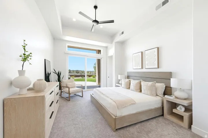 Bright bedroom featuring a vaulted ceiling and a ceiling fan
