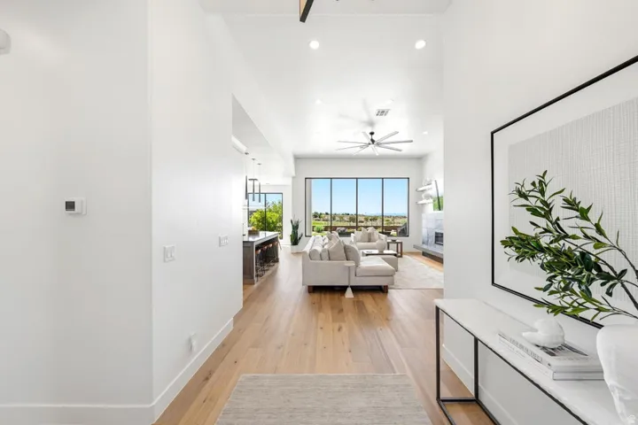 Open-concept living space with wood-finish flooring, vaulted ceilings, and a contemporary ceiling fan