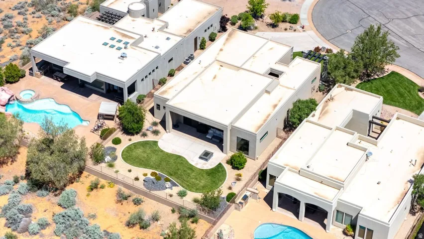 Expansive outdoor living area featuring a freeform swimming pool, integrated spa, and desert-inspired landscaping