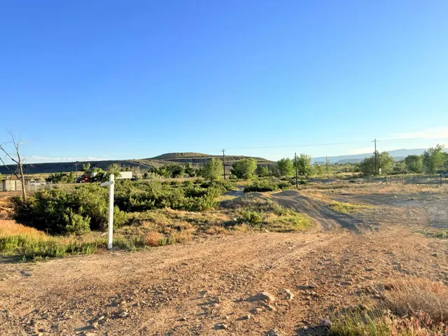 Expansive natural landscape with varied terrain and distant hills under a clear sky