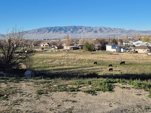 Expansive rural landscape featuring a prominent mountain range backdrop